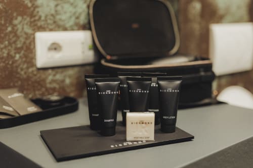 Set di lussuosi amenities dell'hotel Oltre Exclusive Palermo con shampoo, sapone e lozione corpo in bottiglie nere brandizzate