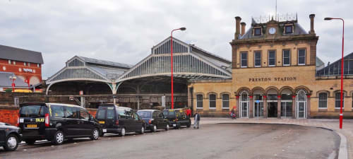 Preston Station exterior with Victorian architecture, taxi rank, and historic building facade in Preston, GB