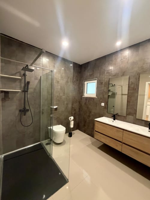 Banheiro moderno na Galagana Charm House com chuveiro sem divisória, duas pias e azulejos cinzentos em Golegã
