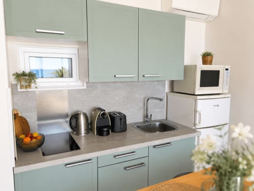 Modern mint green kitchen at Enjoy Nice apartment with sea view, equipped with stainless steel appliances and compact design