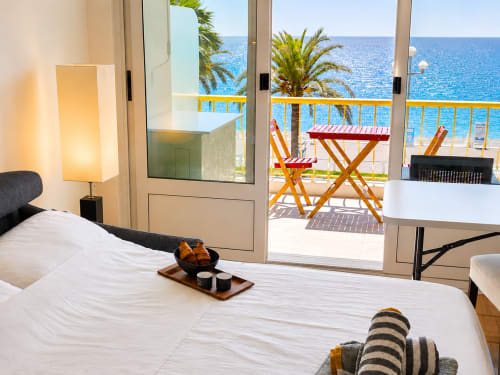Enjoy Nice Sundeck apartment bedroom with sea view, balcony overlooking Mediterranean, palm trees and beach chairs