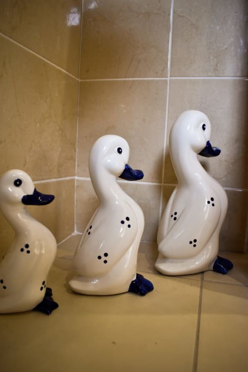 Three decorative white ceramic swan figurines with blue beaks displayed on a bathroom shelf at Knockaderry House in Ennis.
