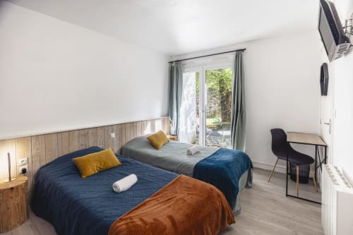Chambre double à l'Hôtel De La Bonnheure à Bracieux avec vue jardin, deux lits, lambris bois et accès patio