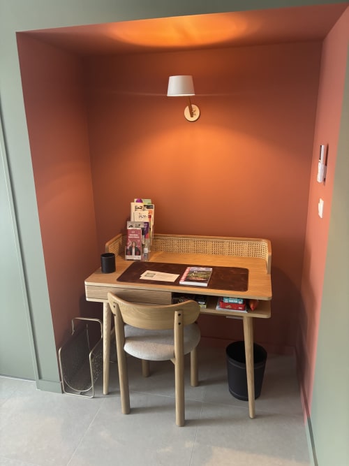 Espace de travail compact dans la chambre Puy de Sancy à la Résidence Les 3 Volcans, Clermont-Ferrand avec bureau en bois, chaise et orange