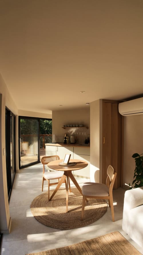 Studio contemporain ouvert au Domaine d'Olga avec table ronde, cuisine et portes donnant sur le jardin à Aniane