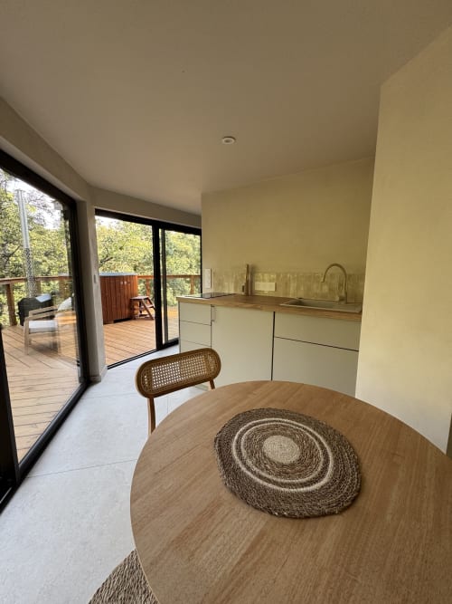Cuisine ouverte moderne et salle à manger au Domaine d'Olga avec vue sur le jardin par les portes vitrées