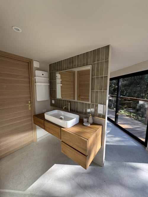 Salle de bains contemporaine avec meuble-lavabo en bois, lavabo blanc rectangulaire et crédence en carrelage vertical au gîte Domaine d'Olga à Aniane