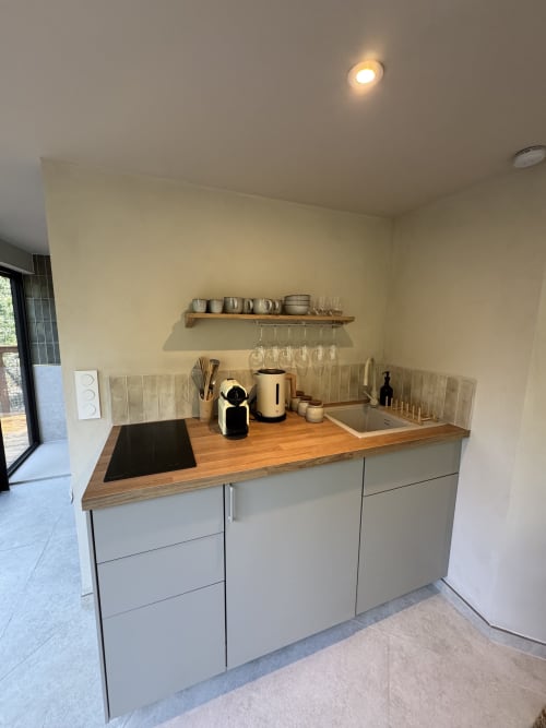 Kitchenette contemporaine avec plan de travail en bois, rangements crème et étagères ouvertes au Domaine d'Olga, Le lodge du grand Chêne