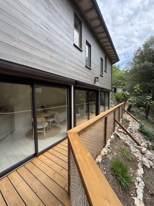 Terrasse moderne avec garde-corps en bois surplombant le jardin de l'hôtel-boutique Domaine d'Olga à Aniane, France