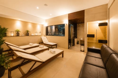Área moderna de spa e relaxamento na ALUGUEASY Brasília com espreguiçadeiras, sauna e espaços de descanso