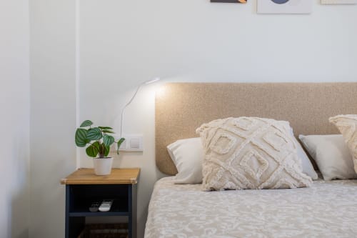 Acogedora habitación en Haus Holiday Homes de San Javier con cabecero beige, almohadas texturadas y planta en la mesilla