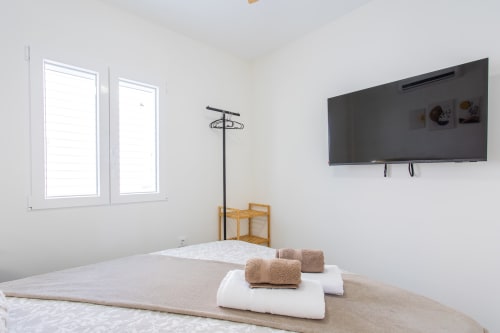 Moderna habitación en Haus Holiday Homes cerca de la playa San Javier, con camas gemelas, TV de pared y comodidades de casa de playa