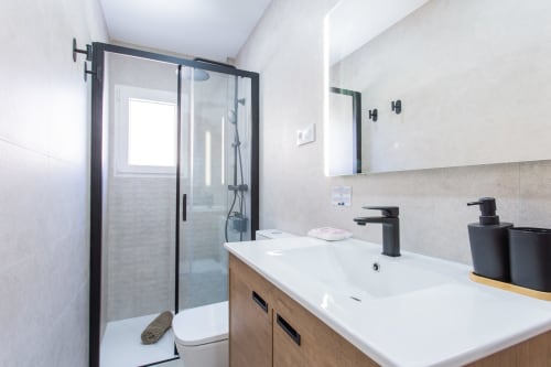 Baño moderno en el dúplex De Lisa de Haus Holiday Homes, San Javier con ducha, lavabo y accesorios negros