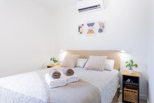 Moderno dormitorio en Haus Holiday Homes, San Javier: cama queen, decoración de cabaña costera, aire acondicionado y toallas enrolladas