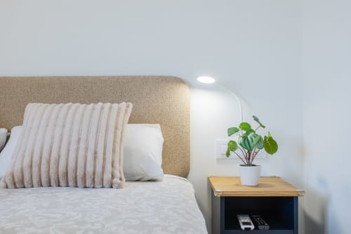 Acogedora habitación en la cabaña Haus Holiday Homes de San Javier con cabecero beige, ropa de cama blanca, almohada rayada y maceta