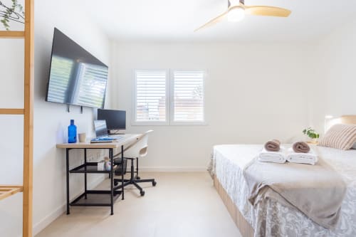Moderno dormitorio con escritorio, televisión y vistas al mar en Haus Holiday Homes, San Javier