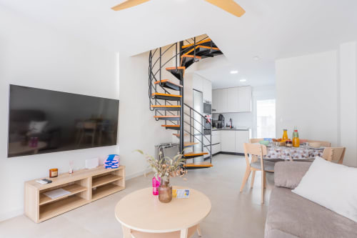 Moderna sala de estar de dúplex en Haus Holiday Homes, San Javier con escalera de caracol, cocina y decoración costera