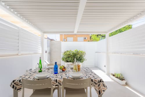 Comedor de dúplex frente al mar con terraza cubierta, mesa puesta, planta verde y vistas al océano cerca de San Javier