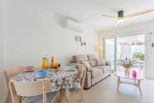 Luminosa sala de estar de la casa San Javier con mesa de comedor, sofá beige y acceso a la terraza en Haus Holiday Homes
