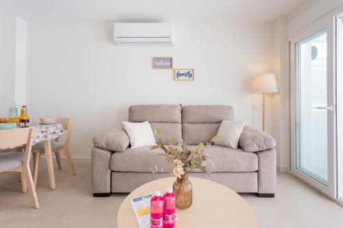 Moderno salón en duplex De Lisa de Haus Holiday Homes, San Javier con sofá gris, mesa redonda y acceso a playa