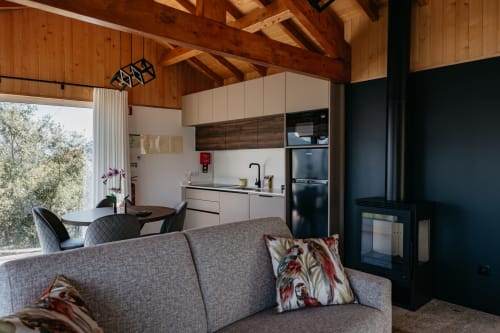 Interior de villa moderna em Villas Eden com sala aberta, vigas de madeira aparente, cozinha, lareira e