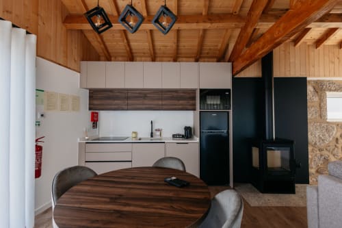 Cozinha e sala de jantar moderna da Villa Eden com vigas de madeira, armários escuros e mesa redonda