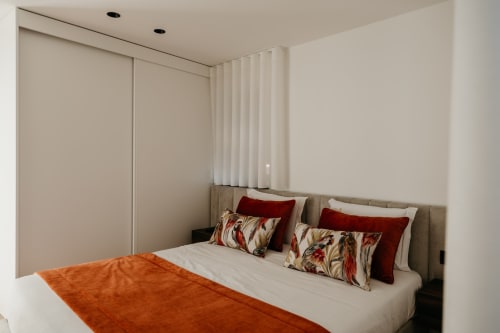 Quarto moderno em Vila Diamante no Villas Eden com cama de almofadas estampadas e detalhes em vermelho