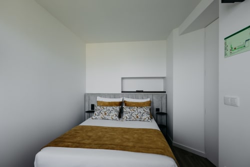 Quarto moderno da Vila Ouro com cama queen, detalhes em ouro e design minimalista em Villas Eden