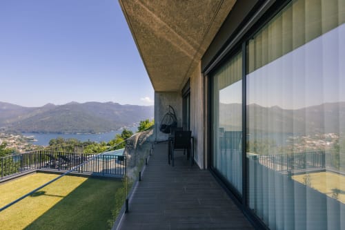 Terraço moderno em Villas Eden com vista para lago e montanhas, com assentos em deck e guarda-corpos de vidro
