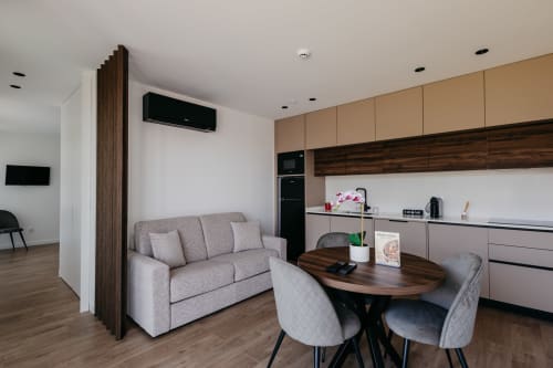 Sala de estar da Villa Rubi com cozinha moderna, sofá cinzento e mesa de jantar em Villas Eden Portugal