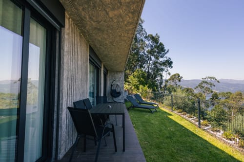 Terraço de moradia moderna com mobiliário preto, espreguiçadeiras e vistas para a montanha no hotel boutique Villas Eden Portugal