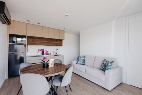 Moderna sala de estar da villa em Villas Eden com cozinha aberta, mesa de jantar e confortáveis assentos com detalhes florais