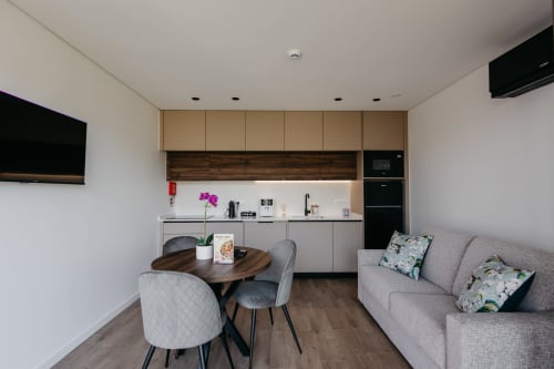 Sala de estar integrada e moderna na Villa Quartz com cozinha, mesa de jantar e sofá cinzento em Villas Eden