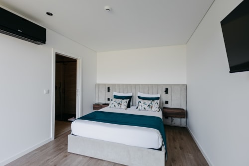 Quarto moderno da Vila Quartz, villa Villas Eden, com cama queen, detalhes em azul-petróleo e decoração neutra