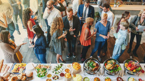 Huéspedes disfrutando de comida y bebidas del buffet en una reunión social del Hotel Rural Cortijo San Ignacio en Telde
