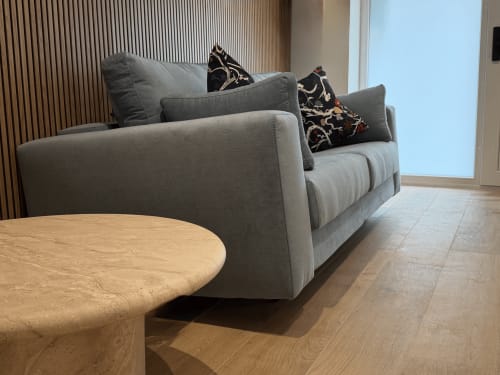 Sala de estar moderna en MTM Rooms con sofá gris, mesa de café de madera y luz natural de las ventanas