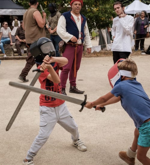 Des enfants participent à un combat à l'épée médiéval au festival du Domaine de Châlus-Chabrol à Châlus, France.
