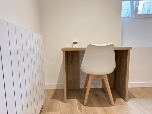 Espacio de trabajo moderno en habitación de hotel MTM Rooms en Santander con escritorio de madera, silla color crema y radiador