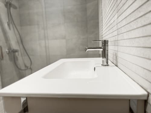 Lavamanos moderno con grifo cromado y paredes de azulejos blancos en el hotel MTM Rooms de Santander