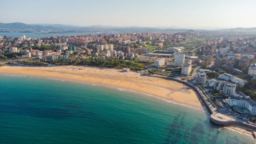 Vista aérea del hotel MTM Rooms en Santander, España con vistas a la playa dorada y las aguas turquesas del Mediterráneo