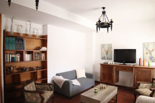 Hostal Rosa - Sala común Nonna en Sigüenza con sofá gris, muebles de madera, TV y decoración clásica