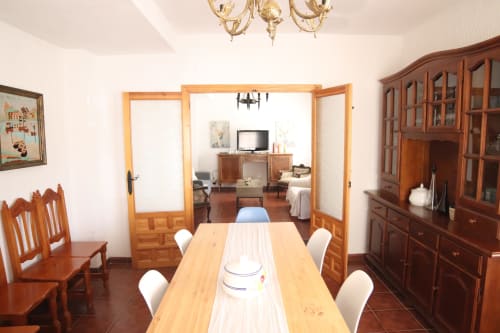 Comedor del Hostal Rosa - Nonna en Sigüenza con mesa de madera, sillas y mobiliario tradicional