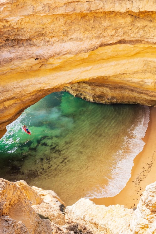 Praia escondida com águas esmeraldas e falésias douradas perto da Villa Odyssey em Albufeira, Portugal