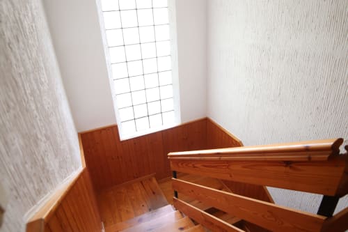 Escalera de madera en Hostal Rosa - Nonna, Sigüenza con luz natural de tragaluz