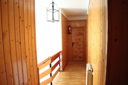 Pasillo de madera en Hostal Rosa-Nonna en Sigüenza con lámpara colgante y puertas