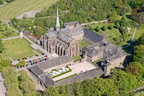 Aerial view of Villa Bianca, a bed and breakfast in Mortroux Dalhem, Belgium, featuring a church, manicured grounds, and