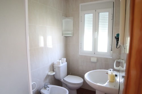Baño limpio en Hostal Rosa - Nonna de Sigüenza con inodoro, lavabo y bañera de esquina