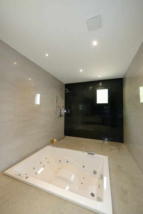 Salle de bain luxueuse avec baignoire balnéo, douche à l'italienne et éclairage ambiant à Villa EOLE, Centuri