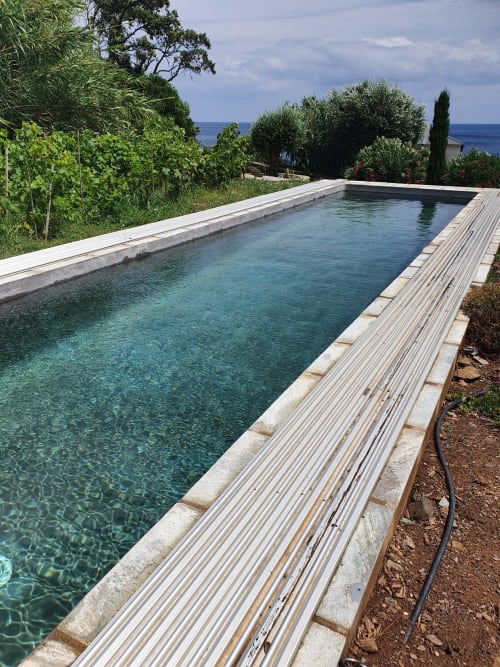 Piscine à débordement contemporaine avec terrasse en bois surplombant la Méditerranée à la Villa EOLE, Centuri, Corse