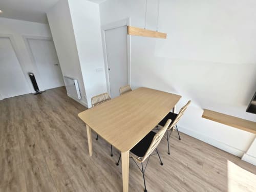 Moderna sala de comedor en apartamento BR SILGAR, Sanxenxo con mesa de madera, sillas y diseño interior minimalista